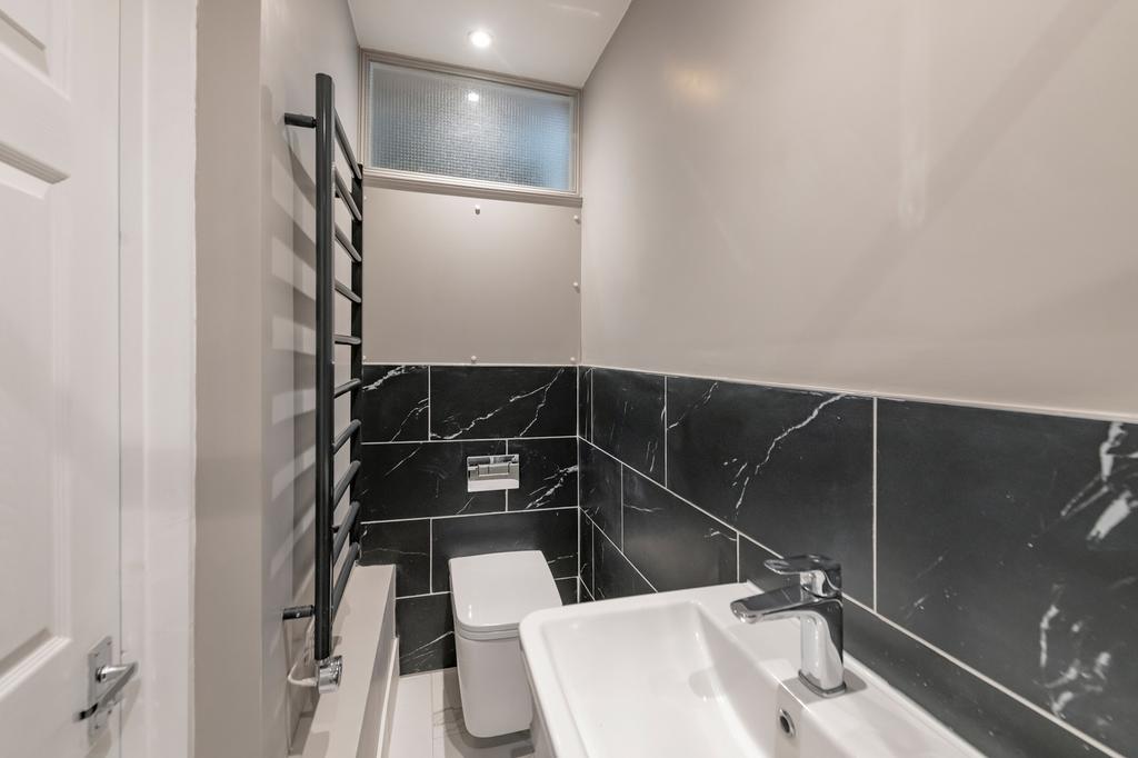 A modern bathroom featuring sleek black tiles a...