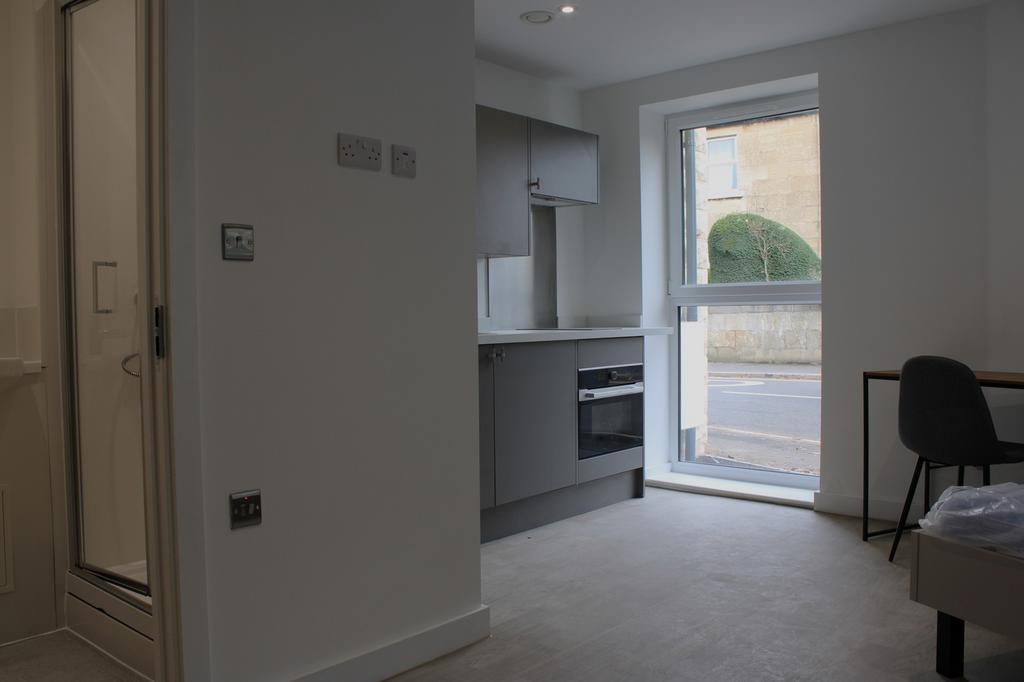 A modern kitchenette with ample natural light a...