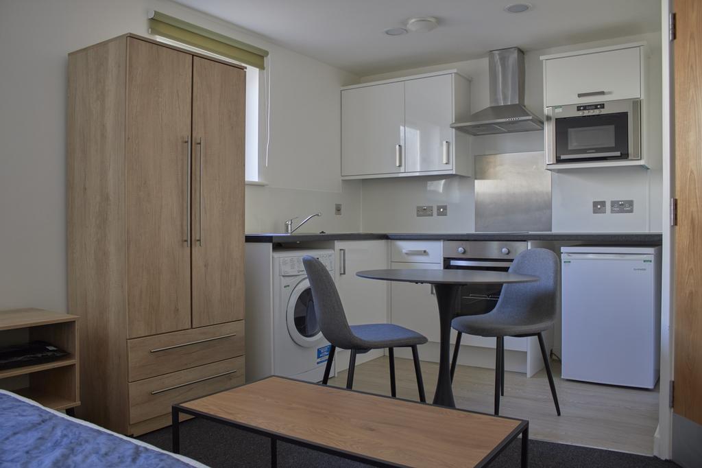 A modern and tidy kitchenette with ample storag...