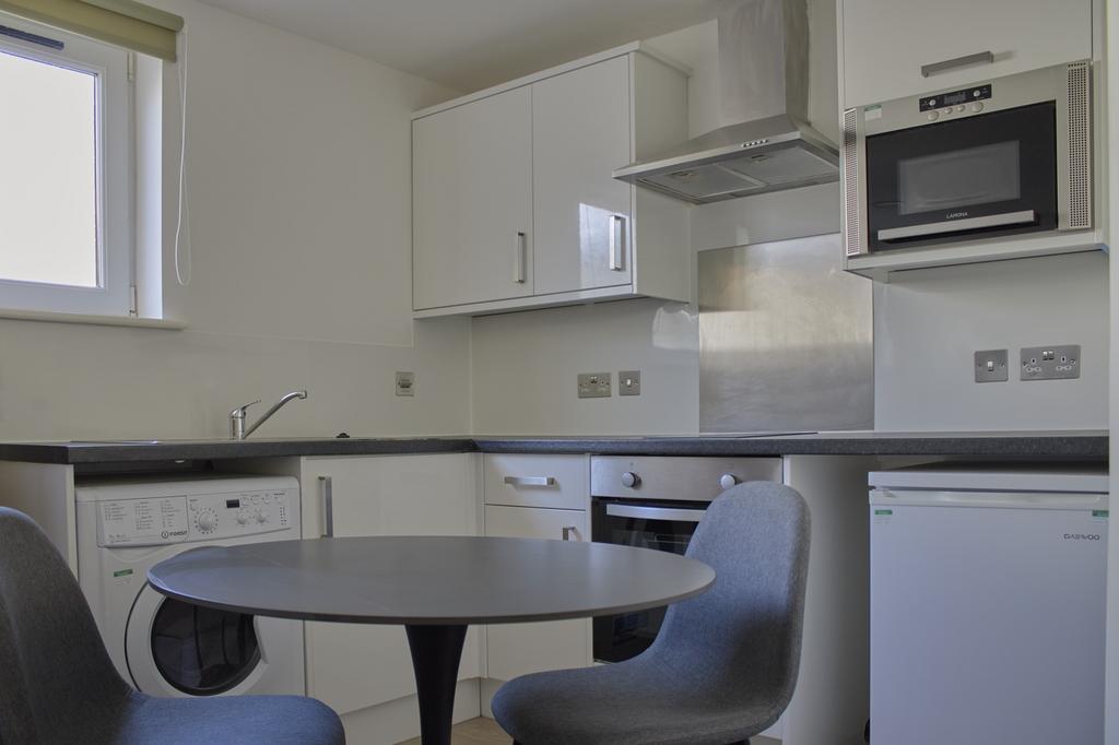 A modern and tidy kitchenette with ample storag...