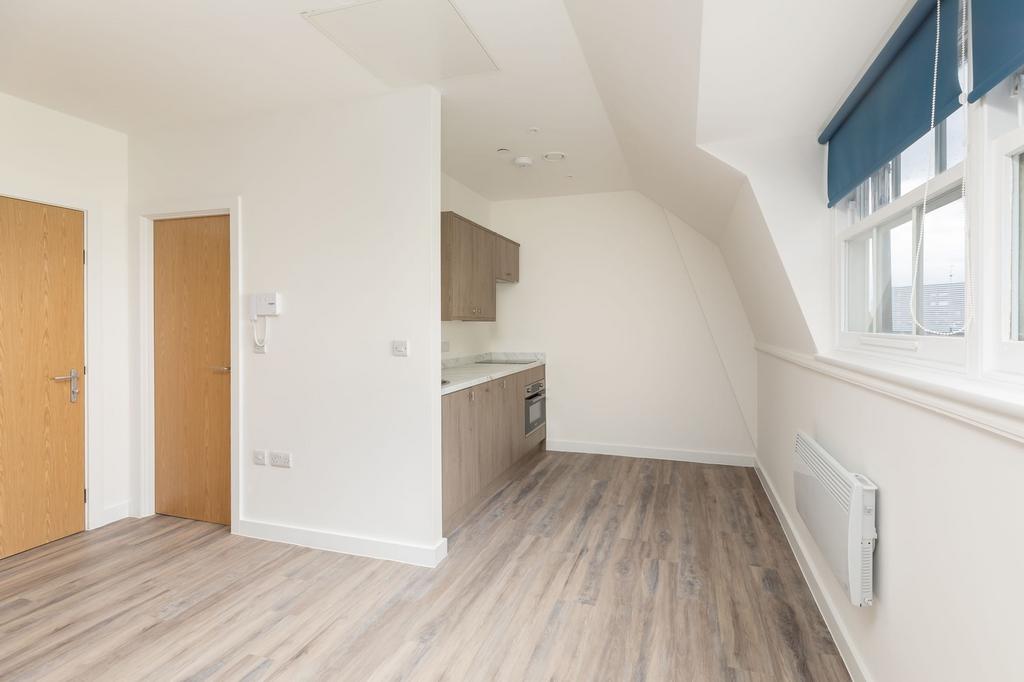 A modern and tidy kitchenette with ample natura...