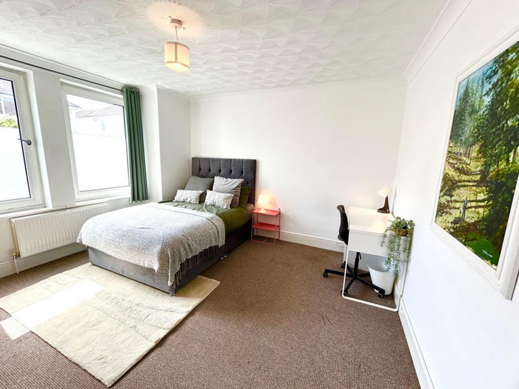 A spacious and bright double bedroom featuring ...