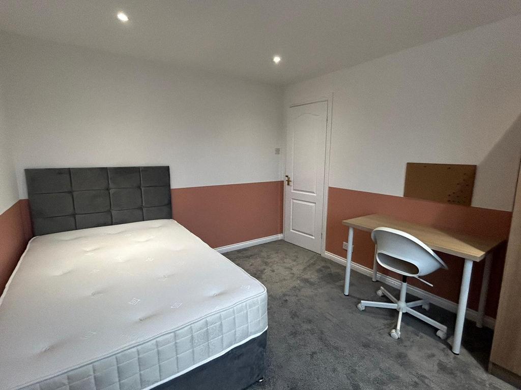 A spacious and well lit double bedroom featurin...