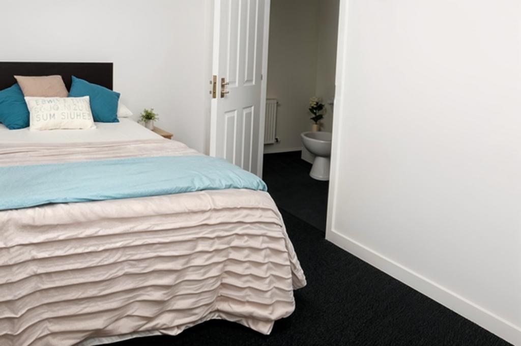 A bright and inviting double bedroom with a com...