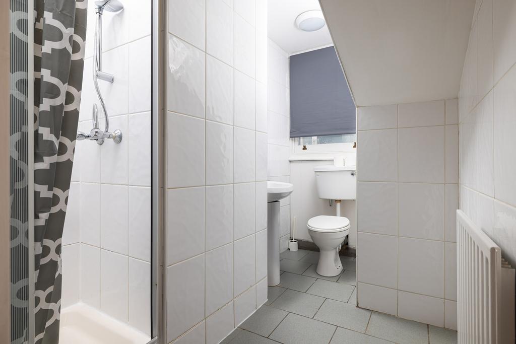 A clean and modern bathroom featuring a shower ...