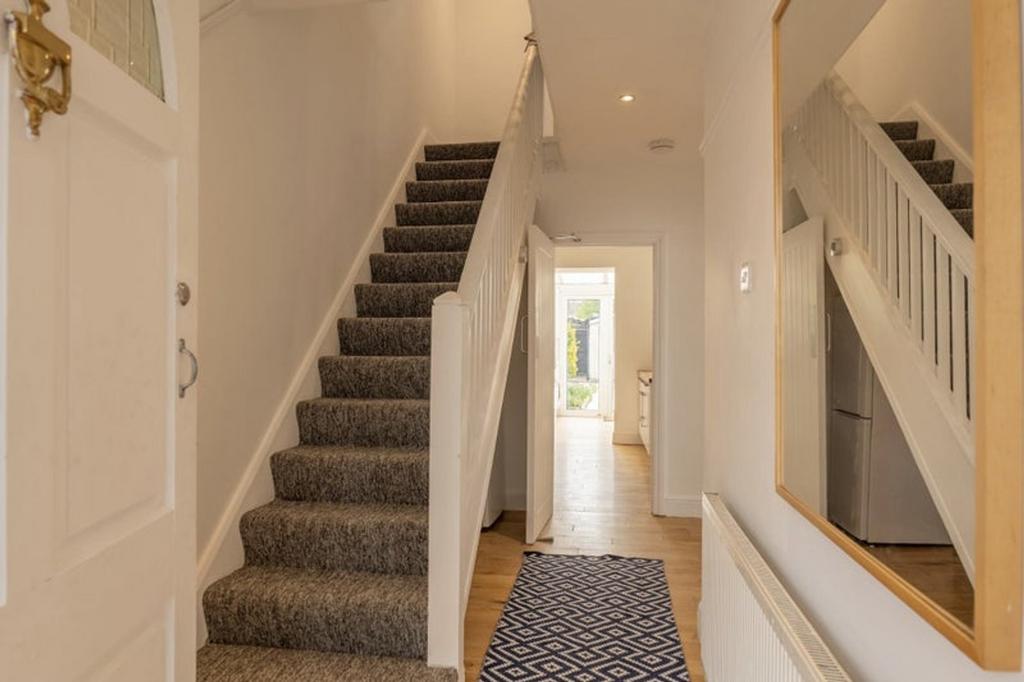 A bright and tidy hallway leading to various pa...