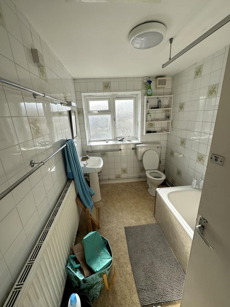 A spacious and well lit bathroom featuring a ba...