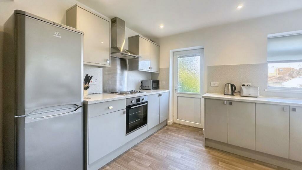 A modern and tidy kitchenette featuring ample s...