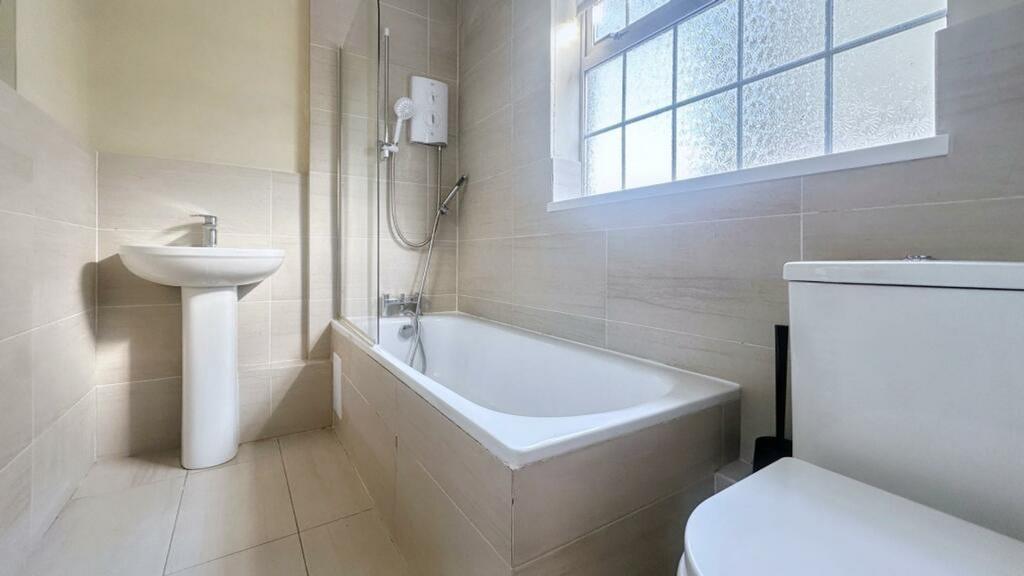 A bright and clean bathroom featuring a bath an...