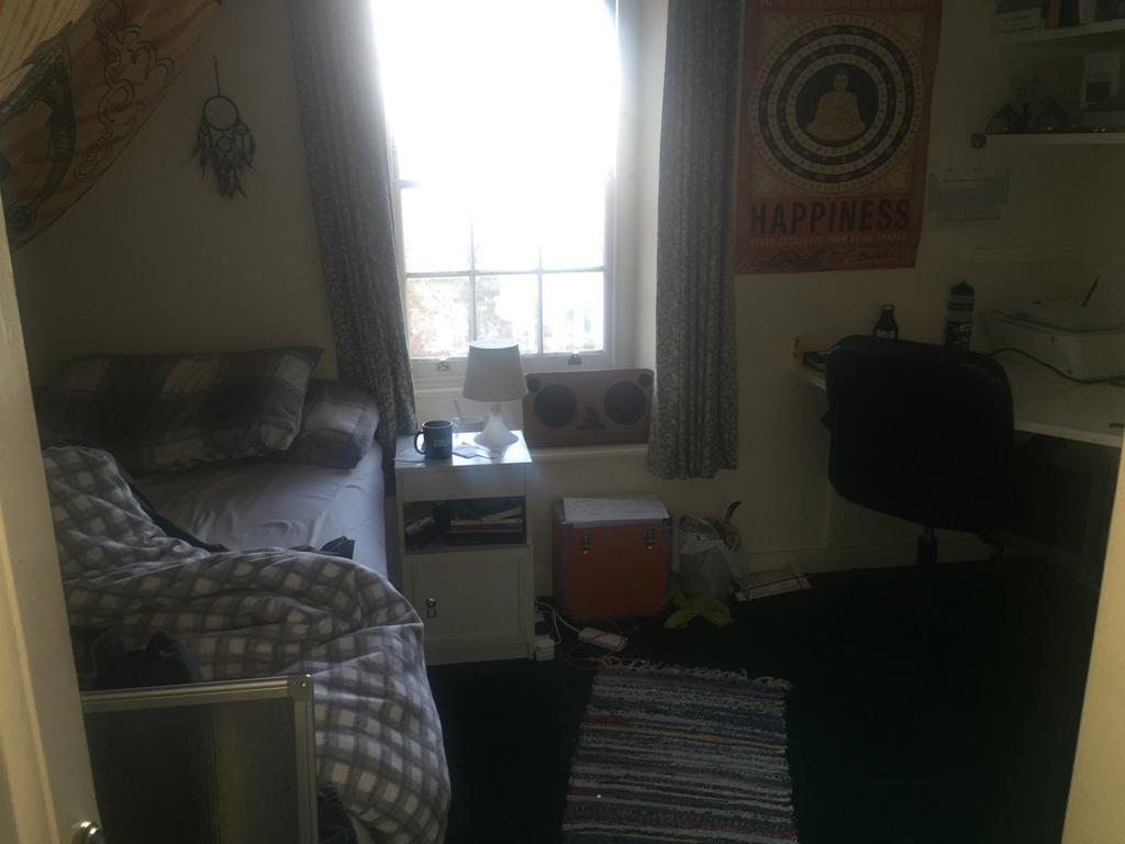 A cozy double bedroom with a bright window, pro...