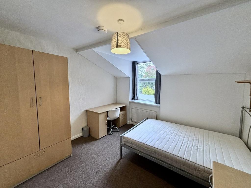 A bright and tidy double bedroom featuring a de...