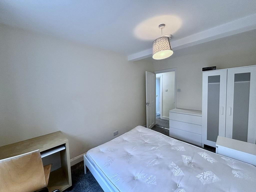 A spacious and well lit double bedroom with mod...