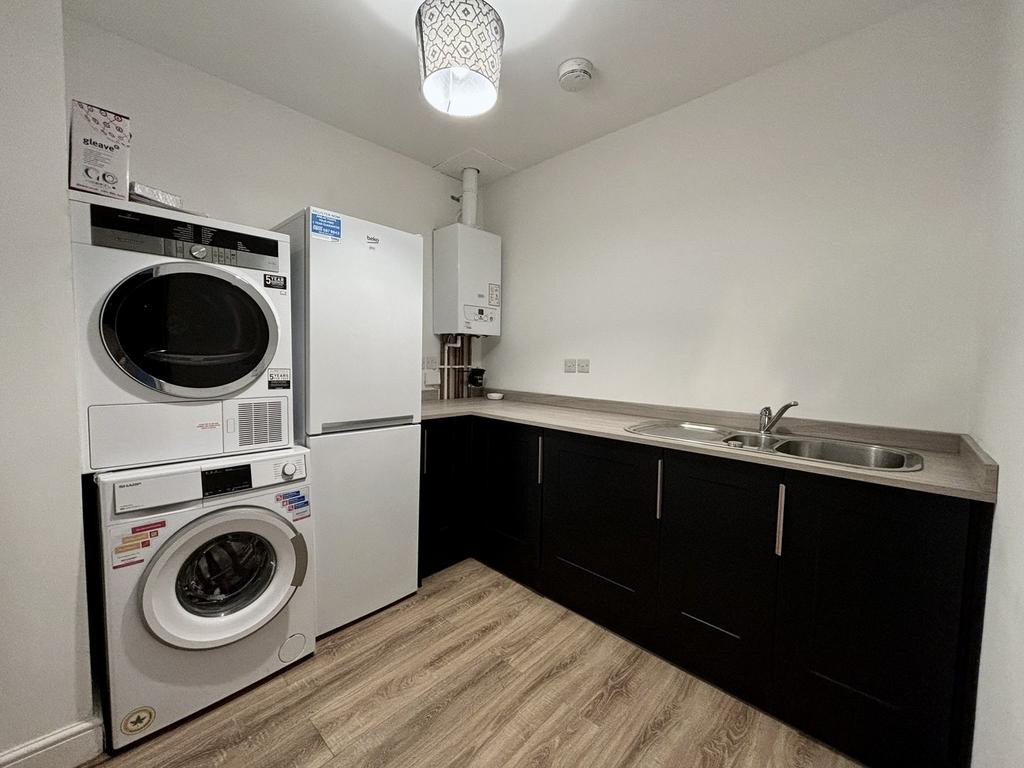 A modern kitchenette featuring sleek cabinets, ...