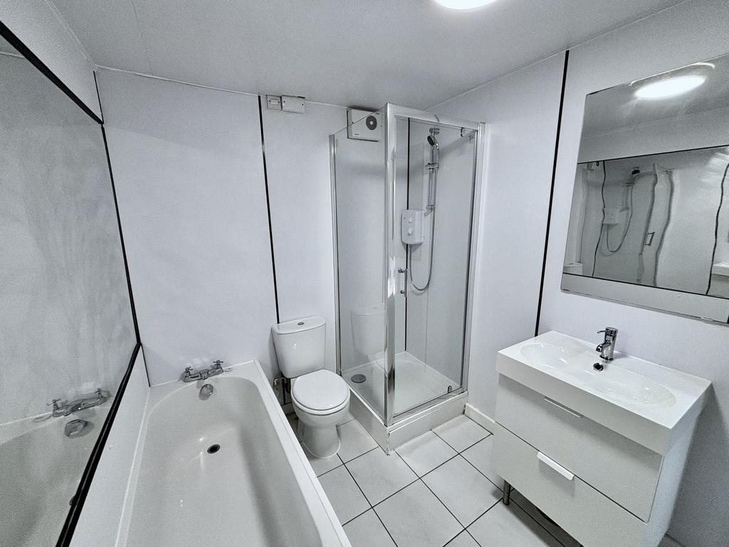 A spacious and modern bathroom featuring both a...