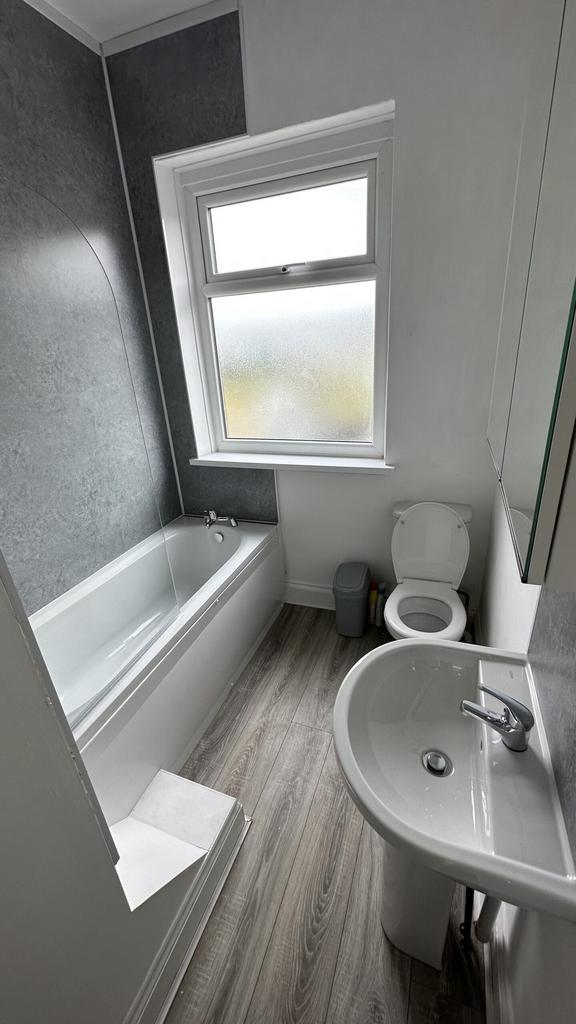 A spacious and clean bathroom featuring a bath ...