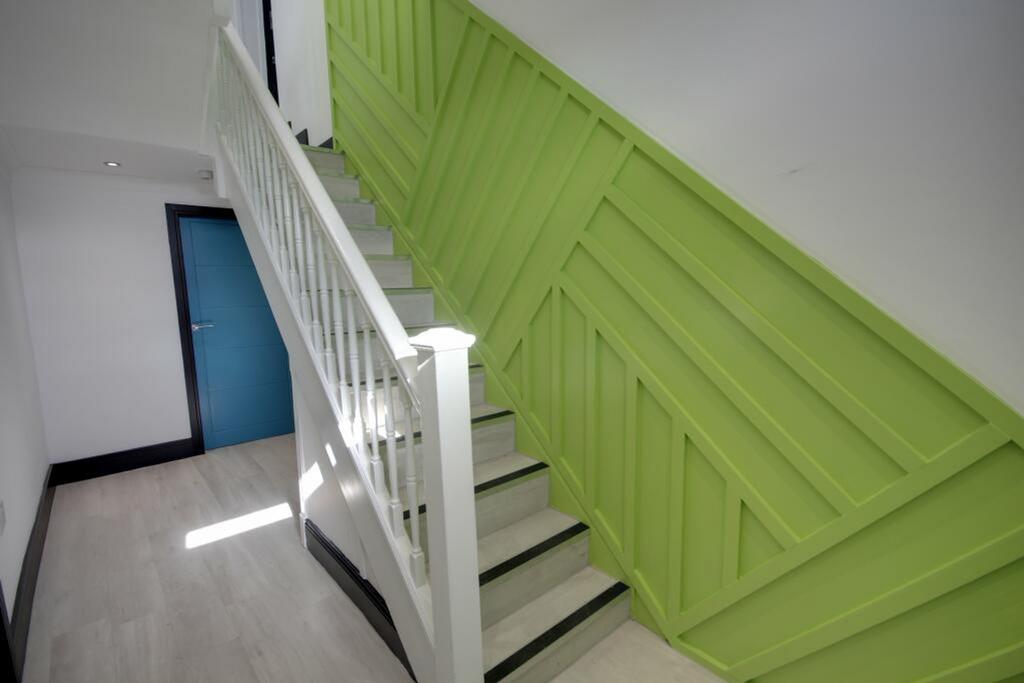 A bright and modern staircase with stylish gree...