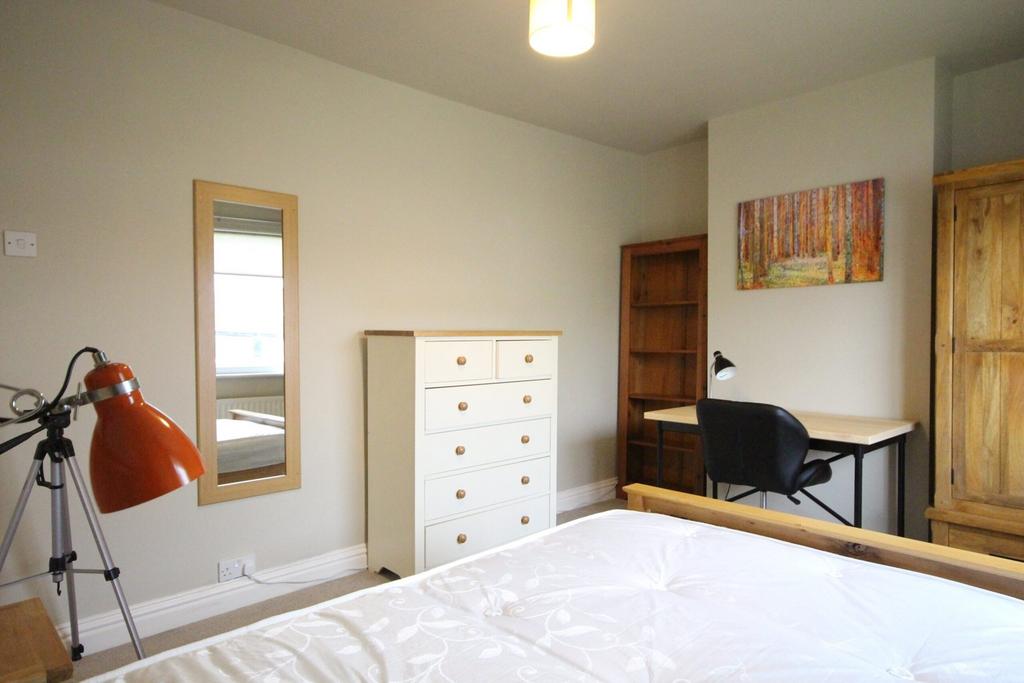 A bright and tidy double bedroom featuring a st...