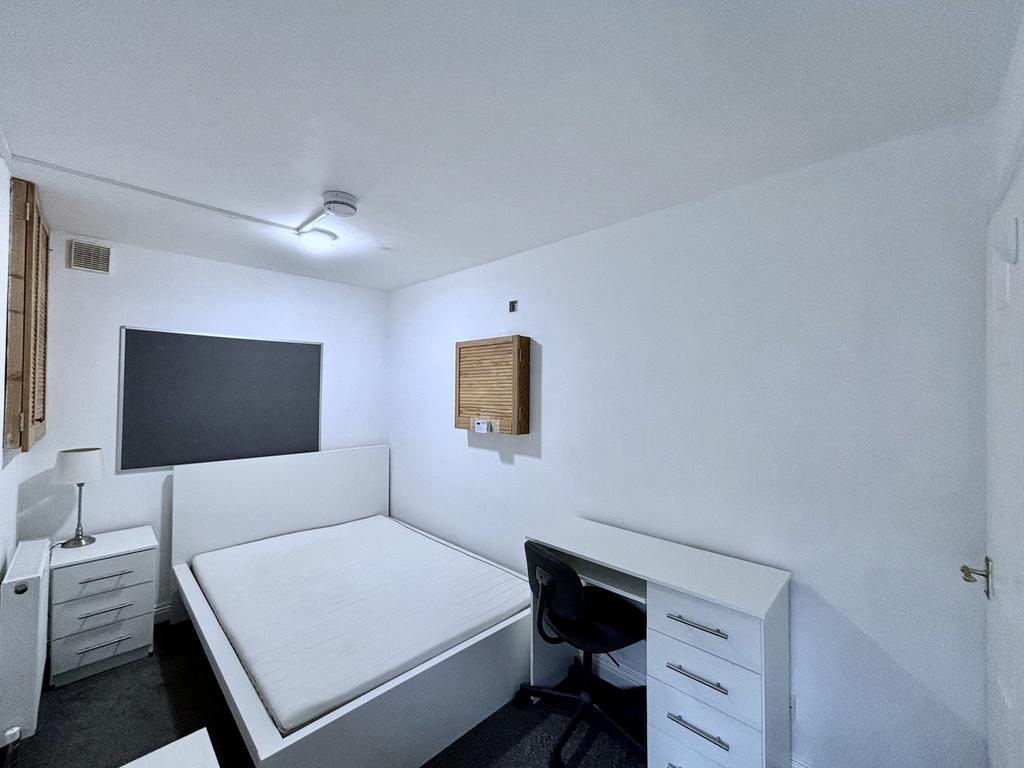 A spacious and inviting double bedroom with a c...