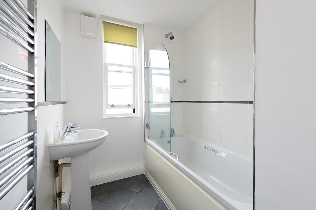 A bright and modern large bathroom featuring a ...