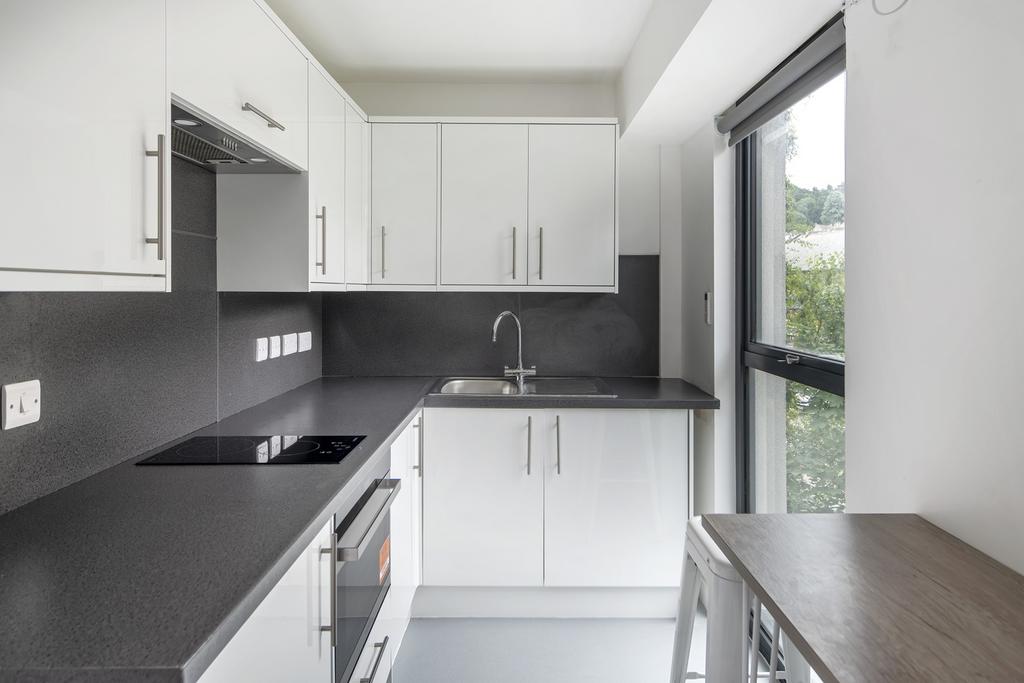 A modern and clean kitchenette with ample natur...