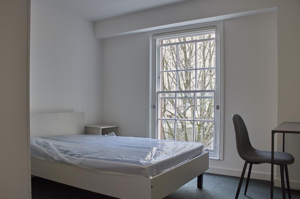 A bright and clean double bedroom with a cozy a...