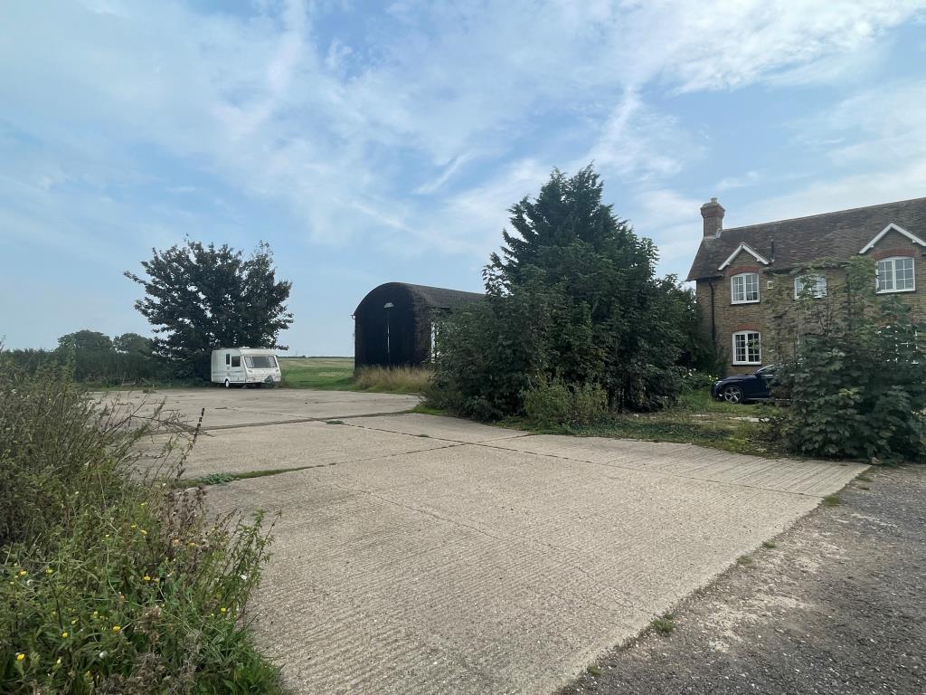 View of site with hardstanding and barn