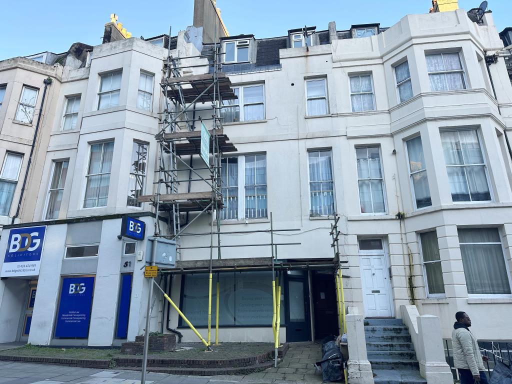 Mid-terrace rendered property with commercial on t