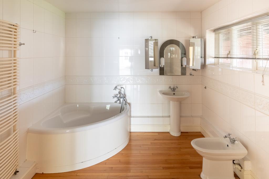 Ensuite bathroom with corner bath and white bathro