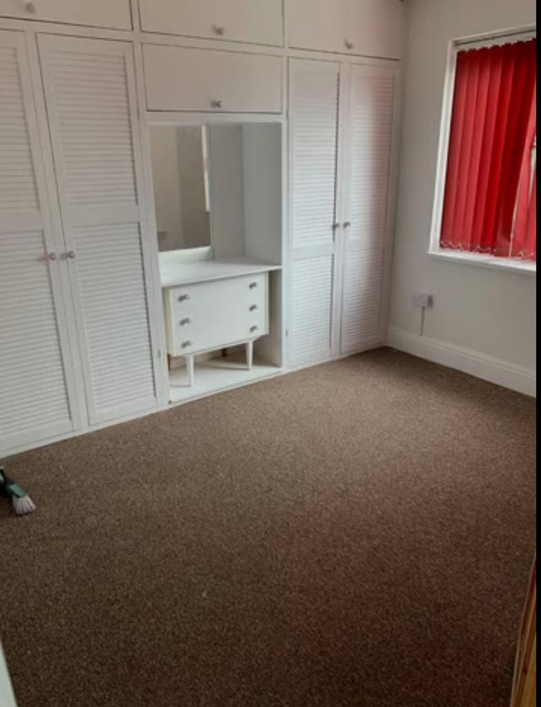 A spacious and tidy double bedroom featuring am...