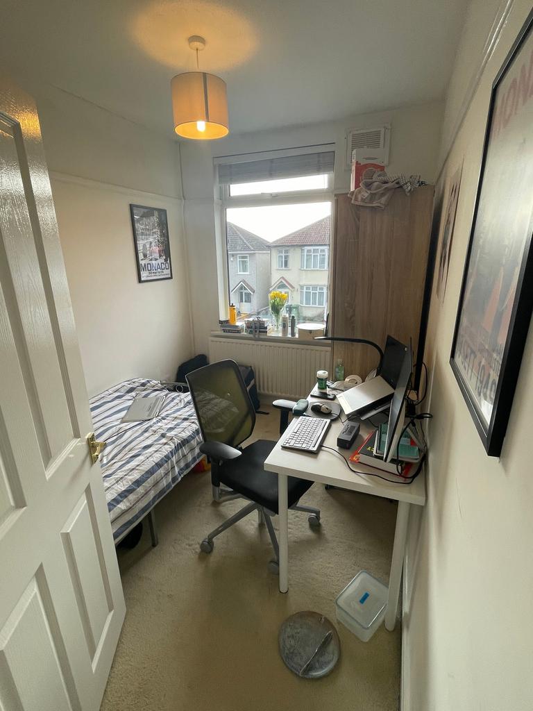 A cozy double bedroom featuring a study area, p...