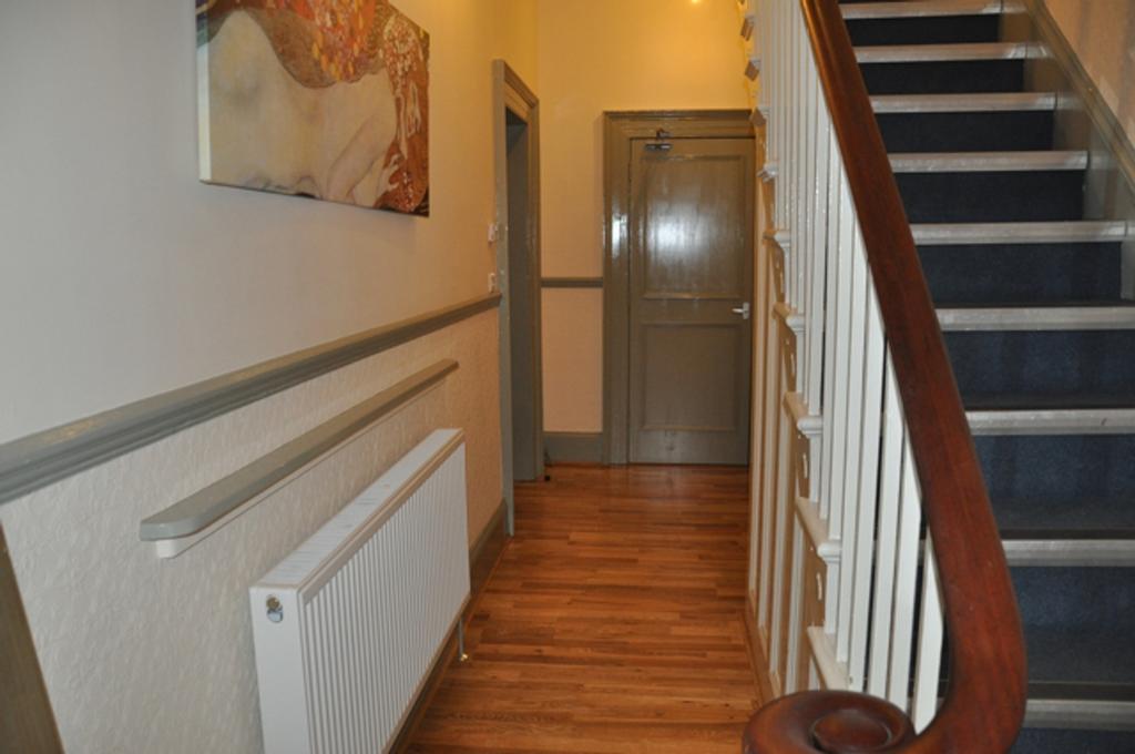 A well-maintained hallway with warm wooden floo...