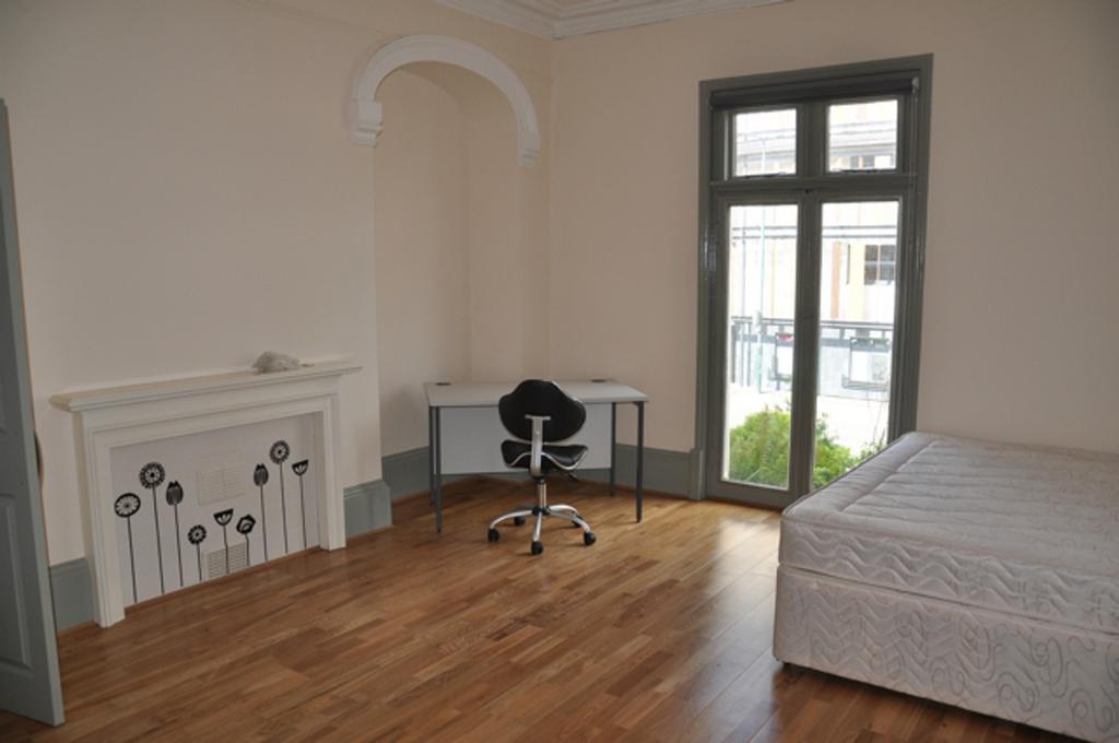 A spacious and bright double bedroom featuring ...