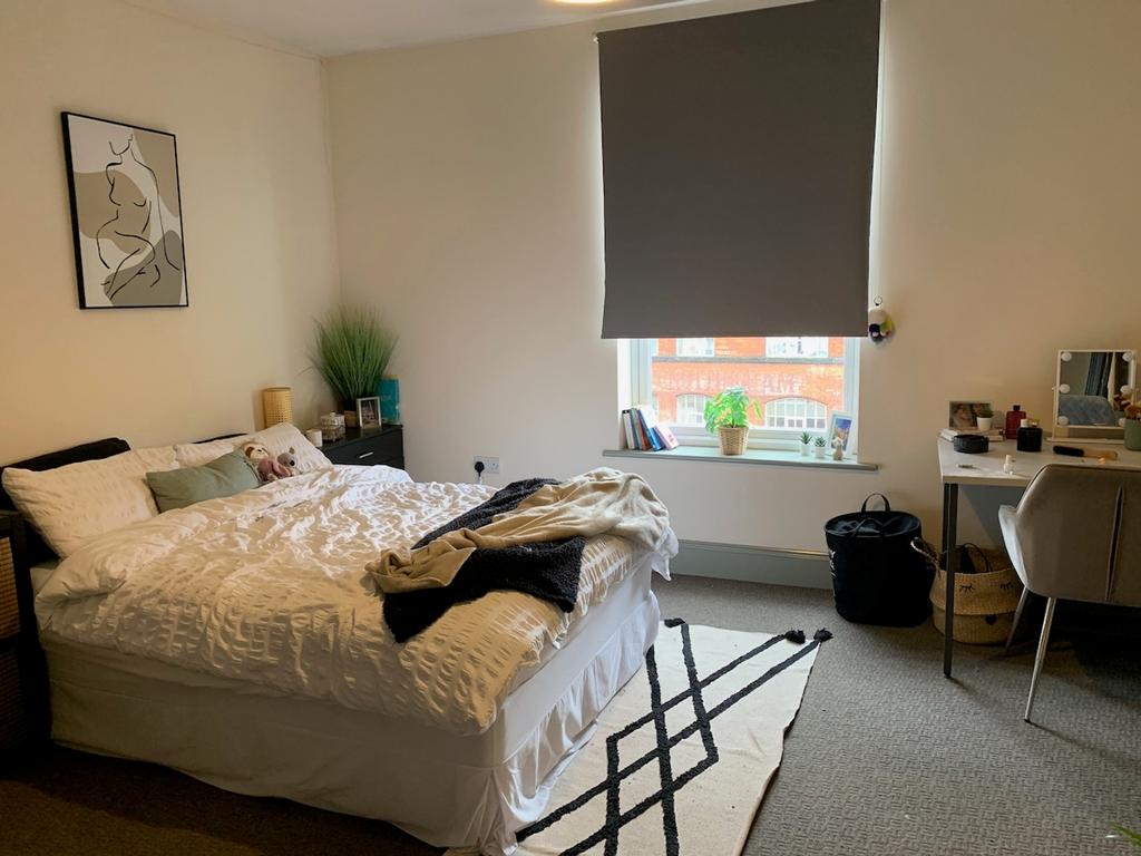 A spacious and bright double bedroom with styli...