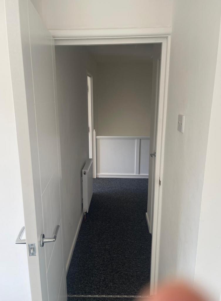 A tidy hallway leading to welcoming spaces, per...