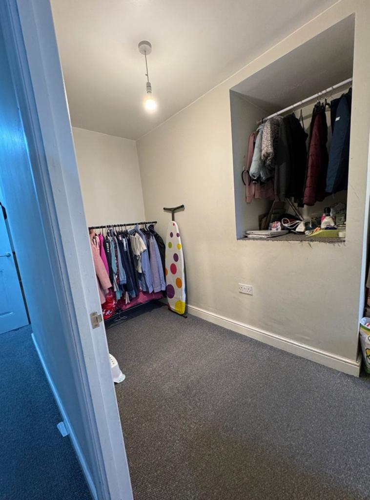 A tidy small storage area with ample hanging sp...