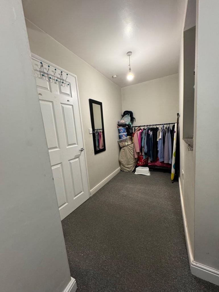 A tidy small storage area with organized clothi...
