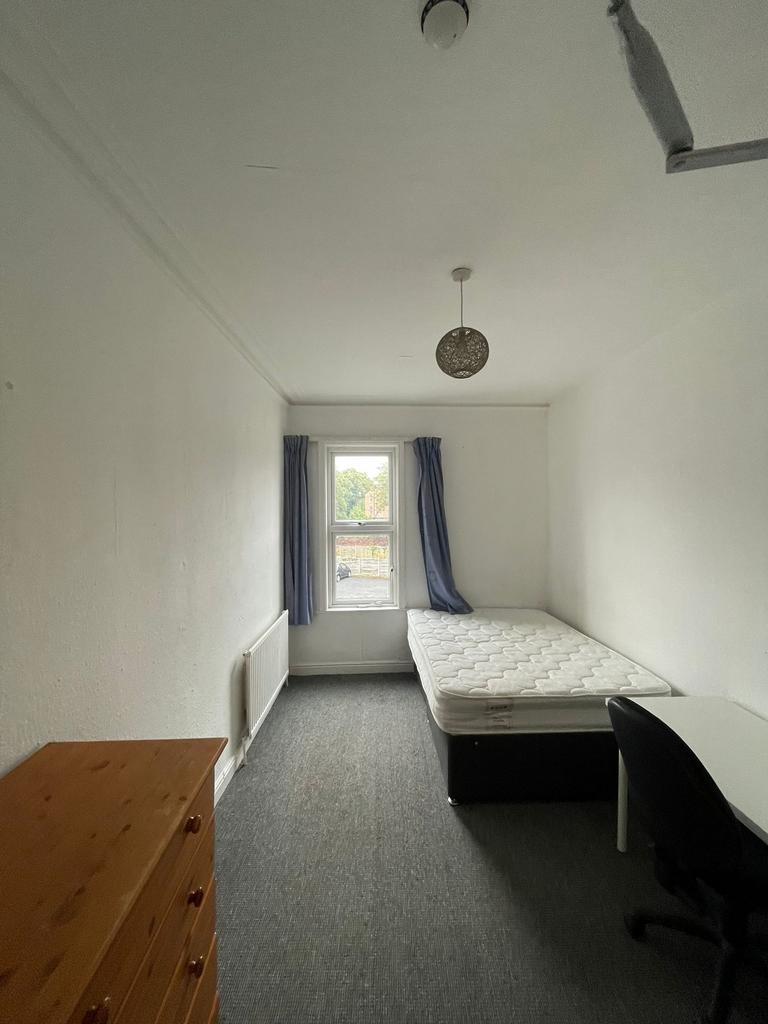 A spacious and tidy double bedroom featuring na...