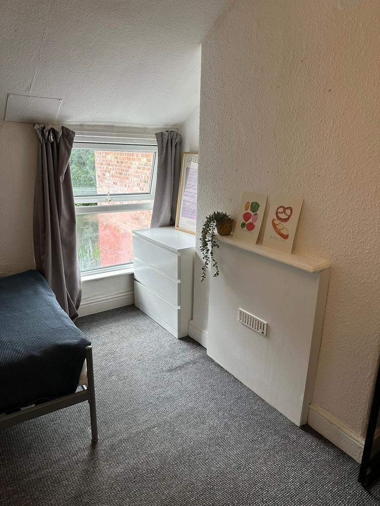 A cozy bedroom featuring a window with natural ...