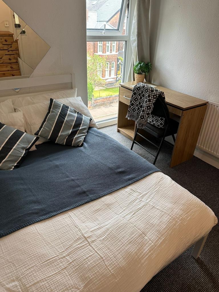 A cozy and well-maintained double bedroom with ...