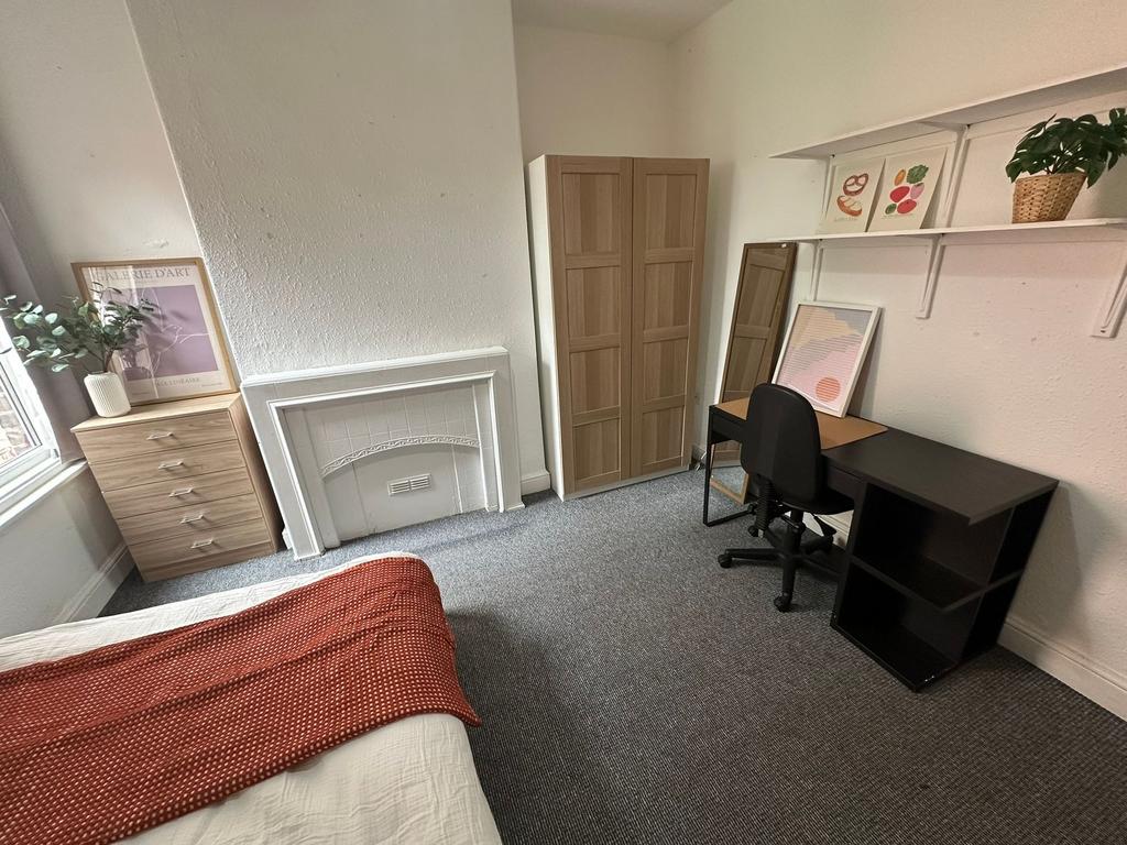 A cozy and well-maintained bedroom featuring a ...