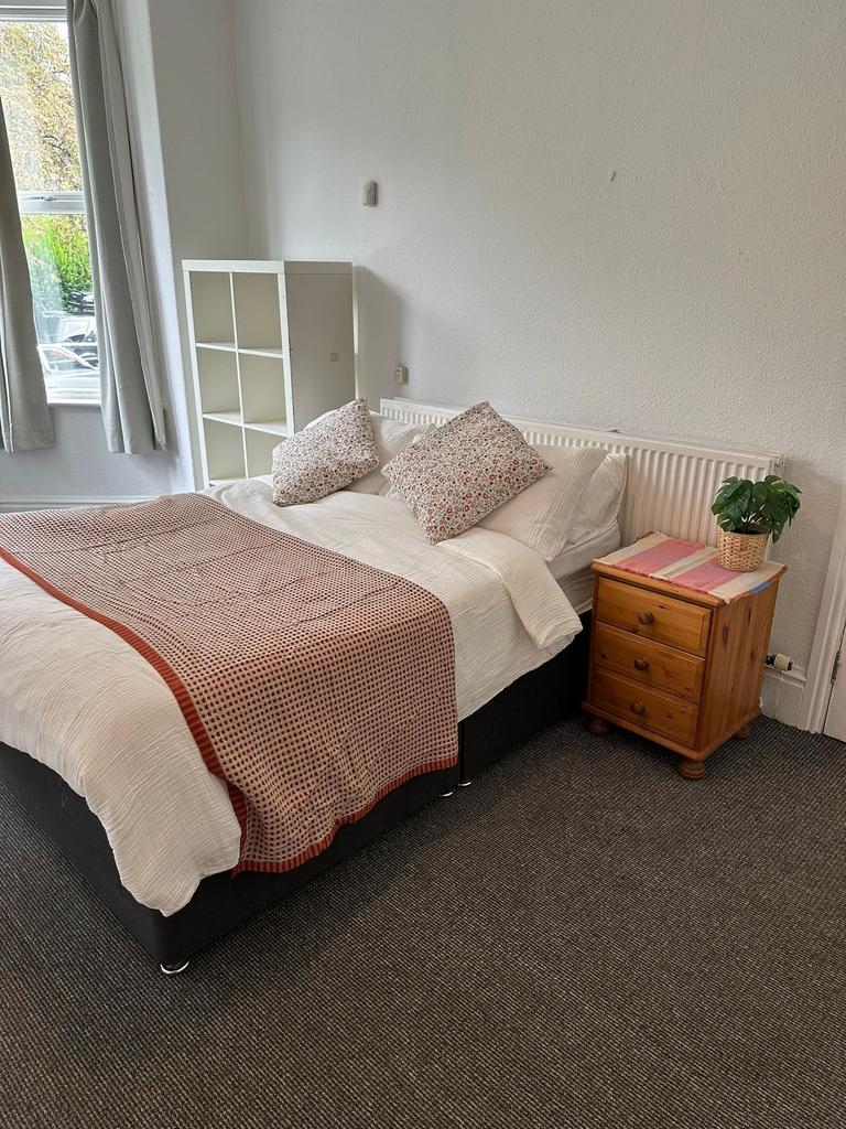 A cozy bedroom featuring a double bed with flor...