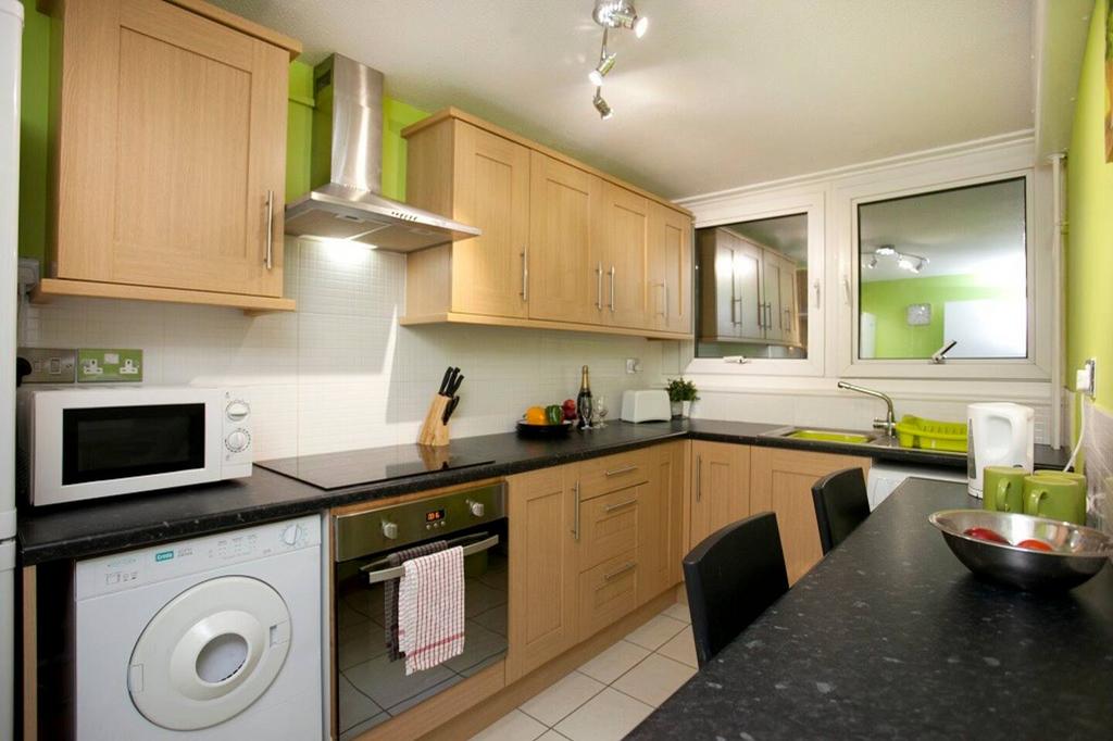 A modern and tidy kitchenette with ample storag...