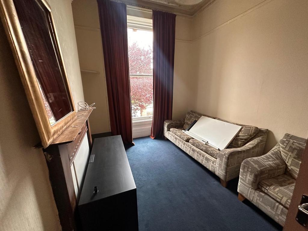 Bright front-facing living room with a large sa...