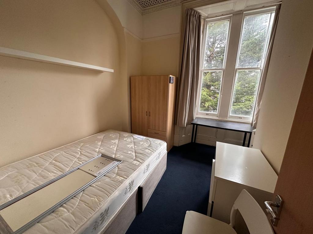 Bright single bedroom with a large sash window,...