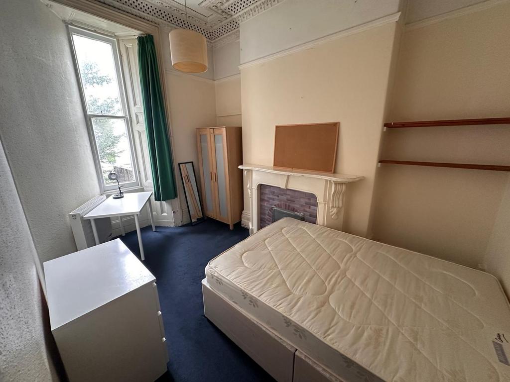 Bright furnished bedroom with a large sash wind...