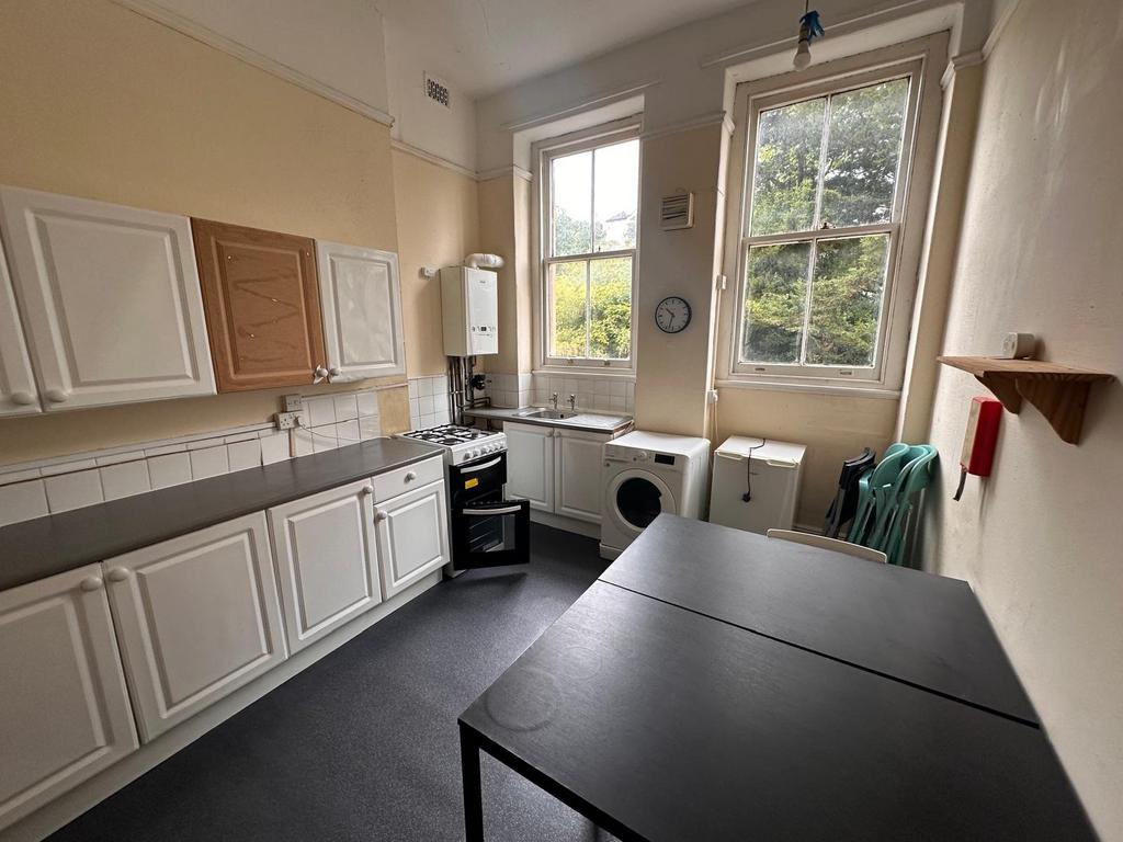 Bright kitchen with high sash windows overlooki...