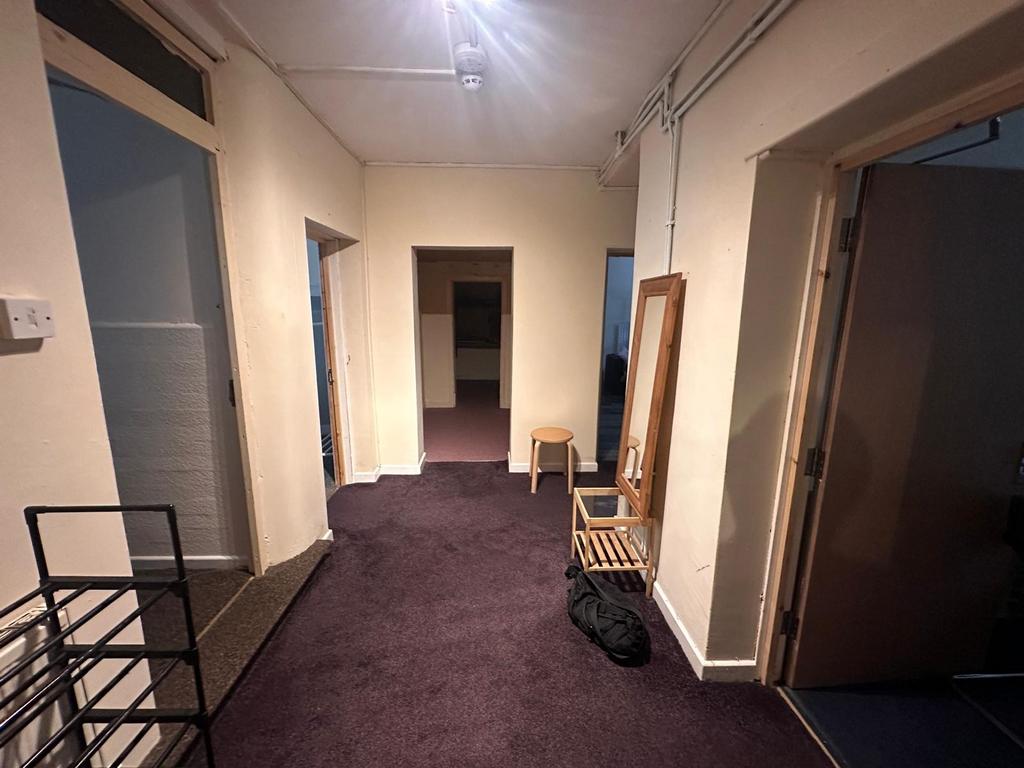 Wide internal hallway with deep-purple carpet, ...