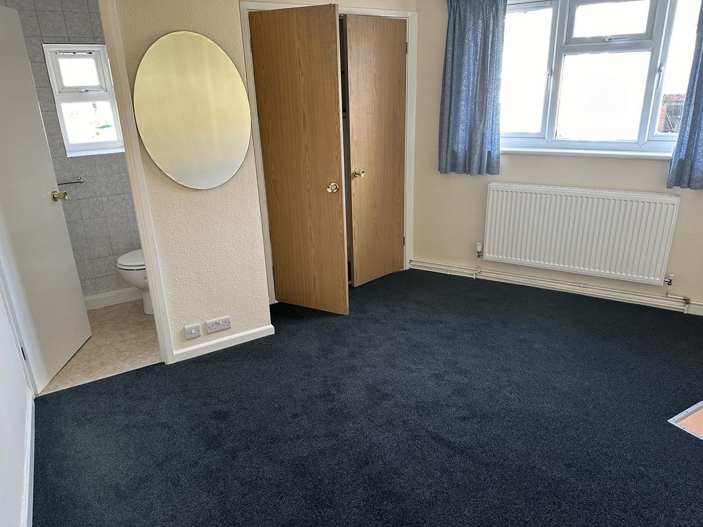 A spacious and well-lit double bedroom featurin...