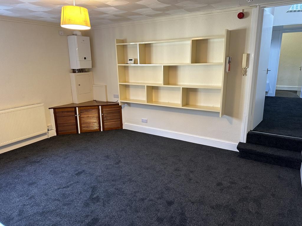 A spacious and tidy living room with ample stor...