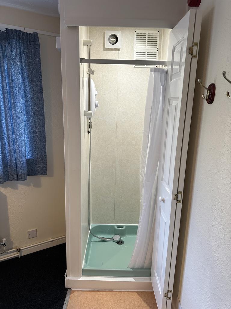 A clean and functional bathroom featuring a sho...